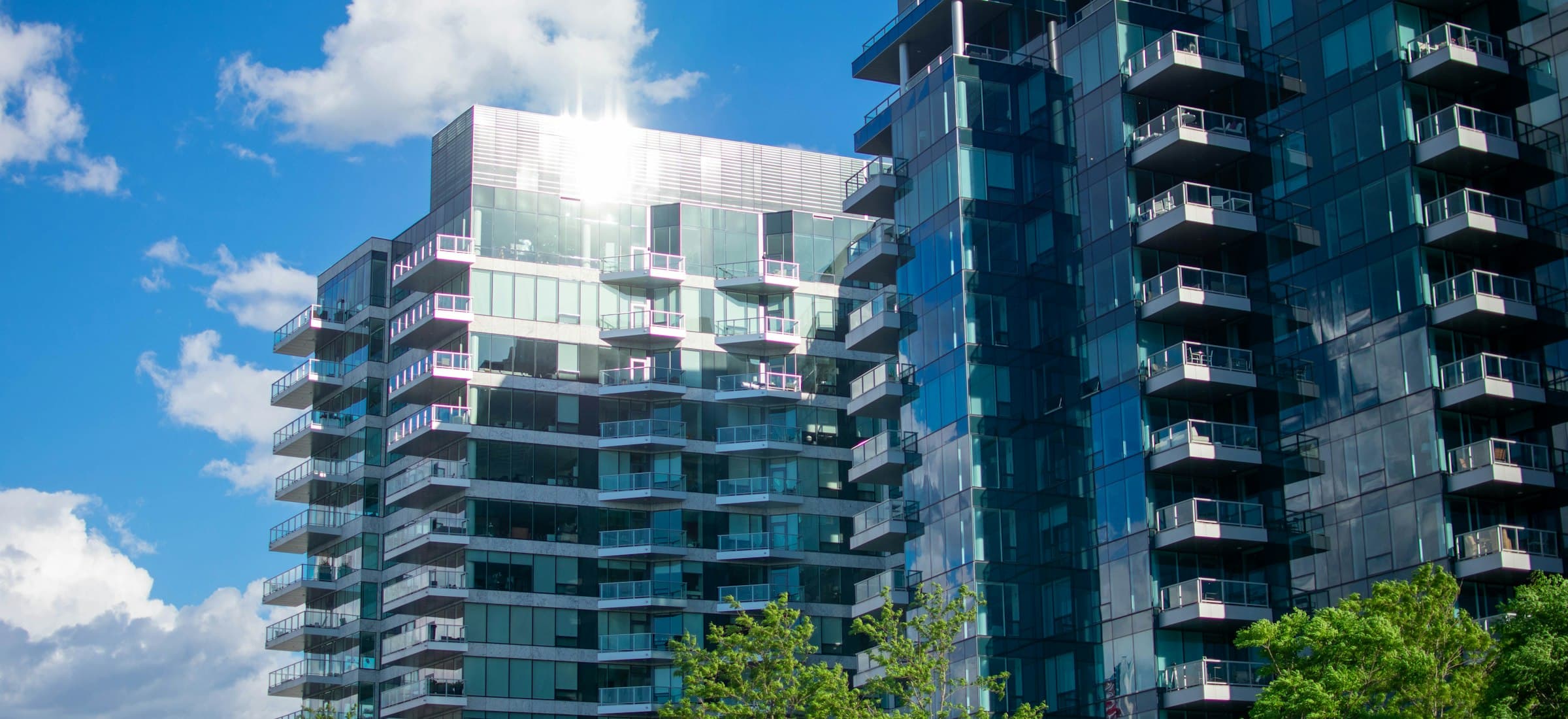 Contemporary apartment tower with glass balconies against a clear sky